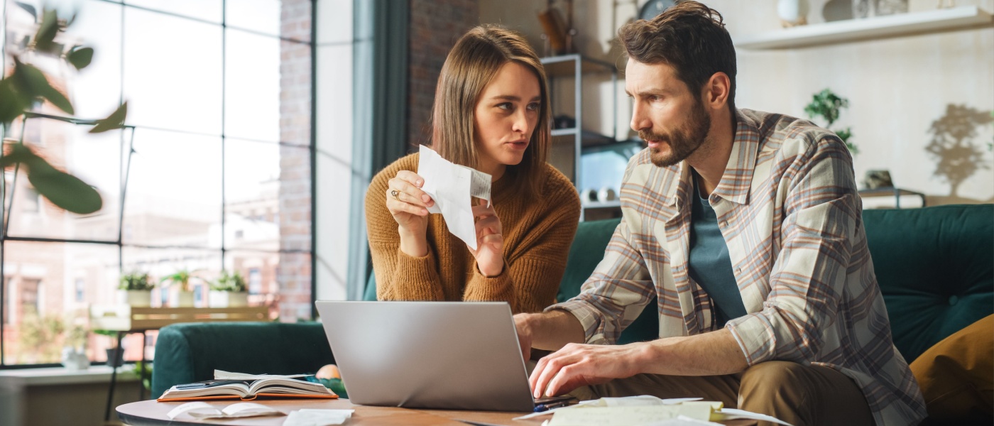 Couple looking over papers as they focus on budgeting for monthly bills.