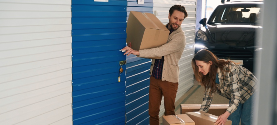 Young couple moving boxes in storage unit