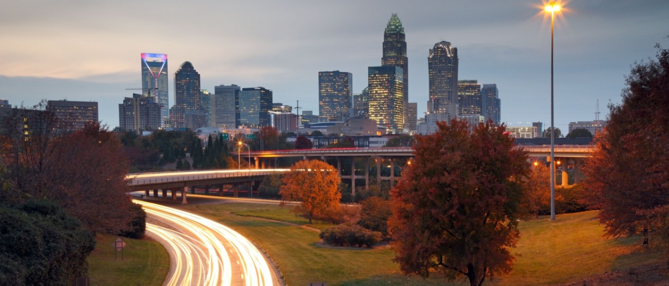 The Charlotte skyline at night highlighting the city's urban landscape and affordable neighborhoods.