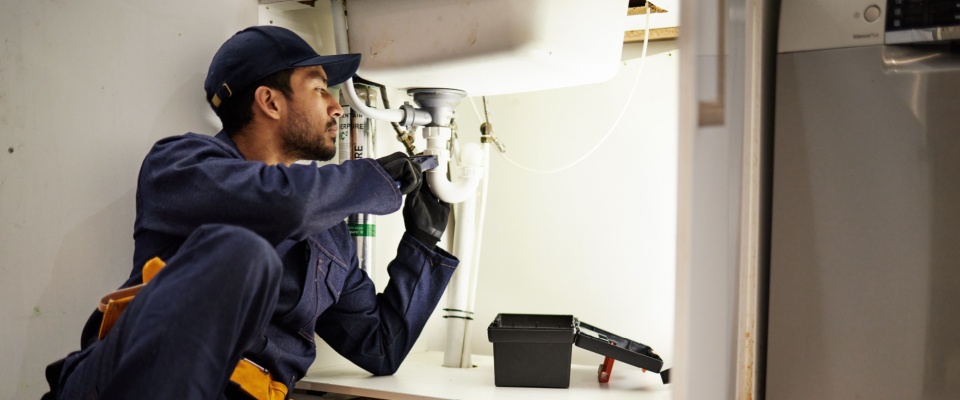 Landlord duties include calling a handyman to inspect a sink’s drainage pipe with pliers while crouching beneath it.
