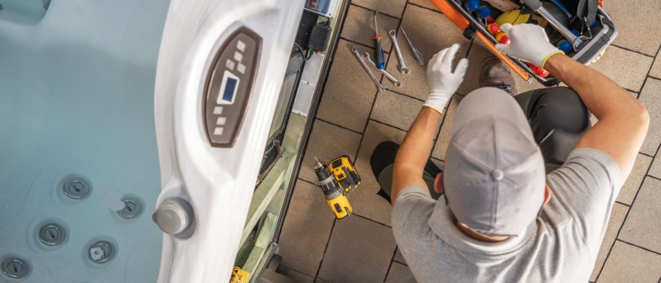 Hot tub technician performing maintenance requests by repairing jets.