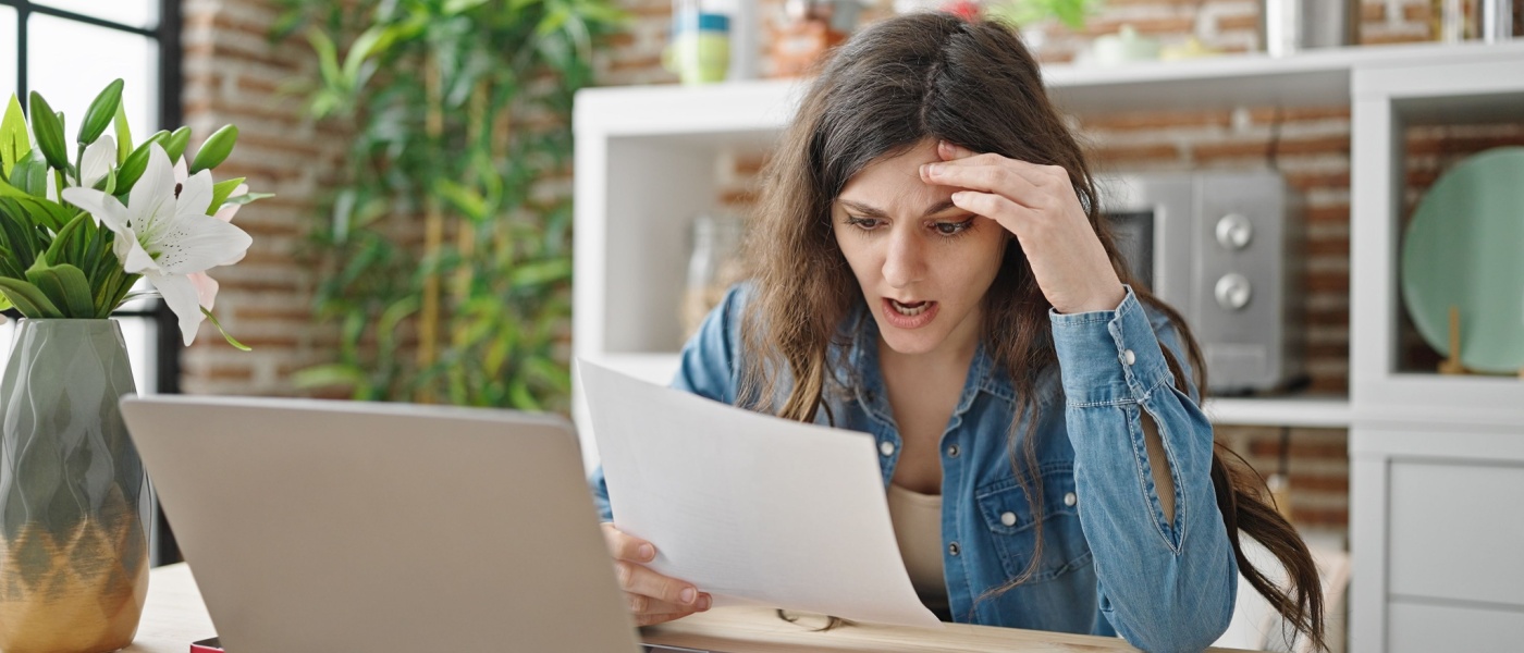 Renter sitting at a table, reading a notice to vacate or eviction letter with a concerned expression.