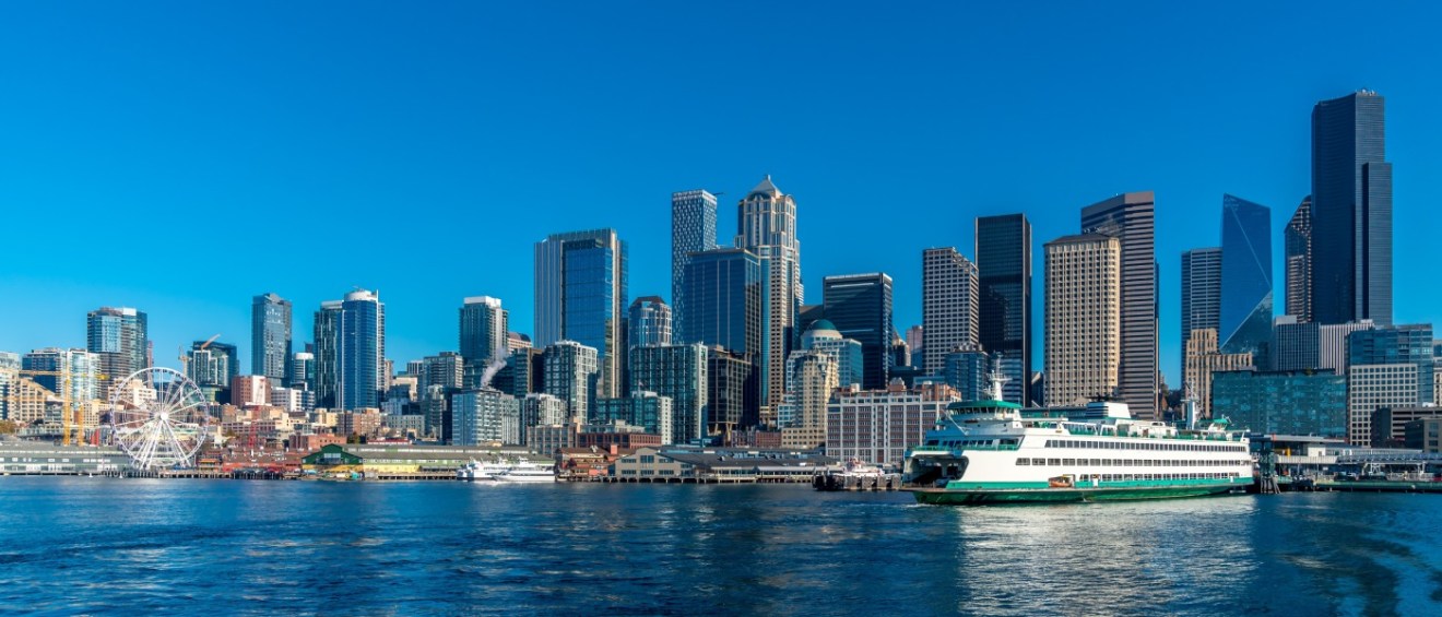 The skyline of Downtown Seattle and a ferry as part of public transport in Seattle.