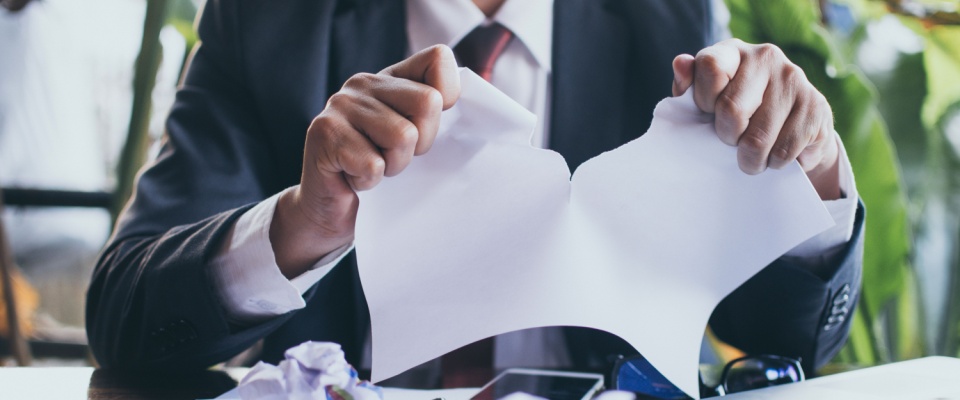 A person ripping up a sheet of paper, symbolizing breaking a lease before it starts.