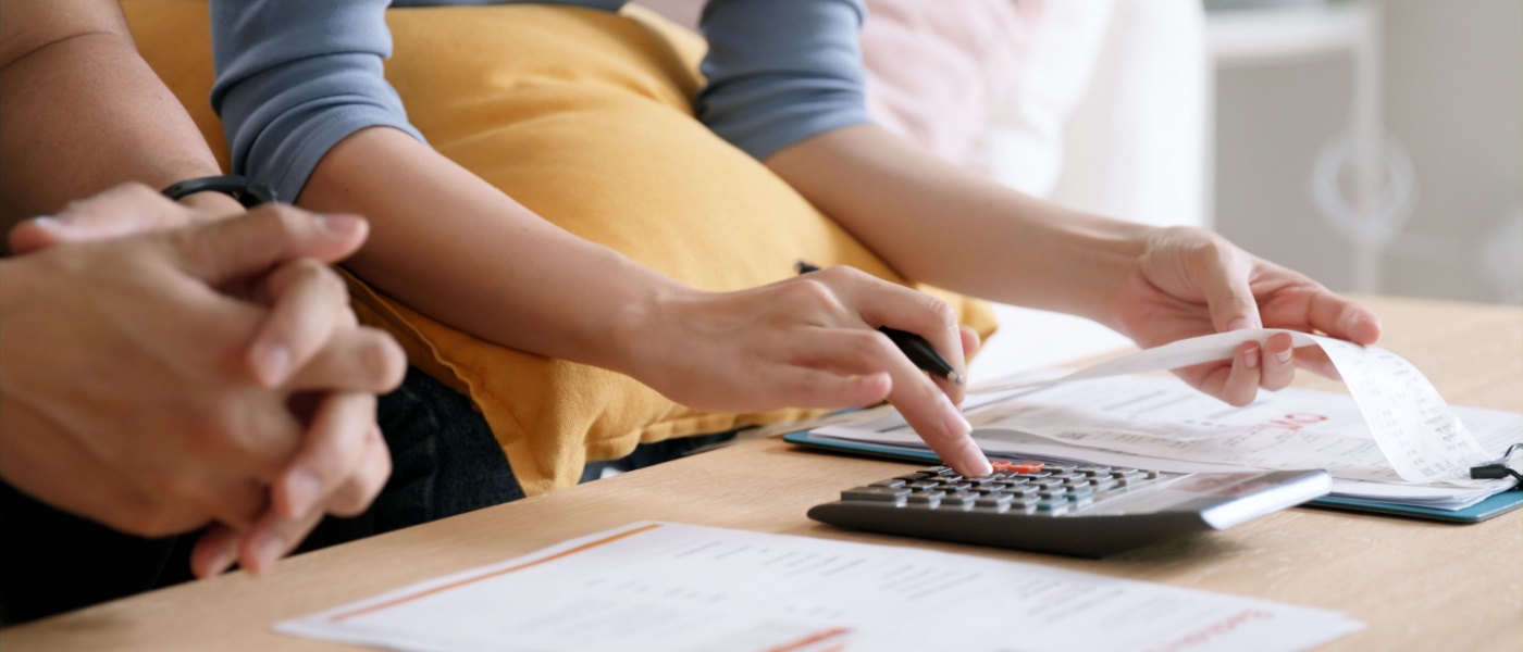 Young couple struggling with rising living costs, past-due bills, and home loan debt, looking worried and stressed. The scene reflects financial challenges and the need for a soft credit check.