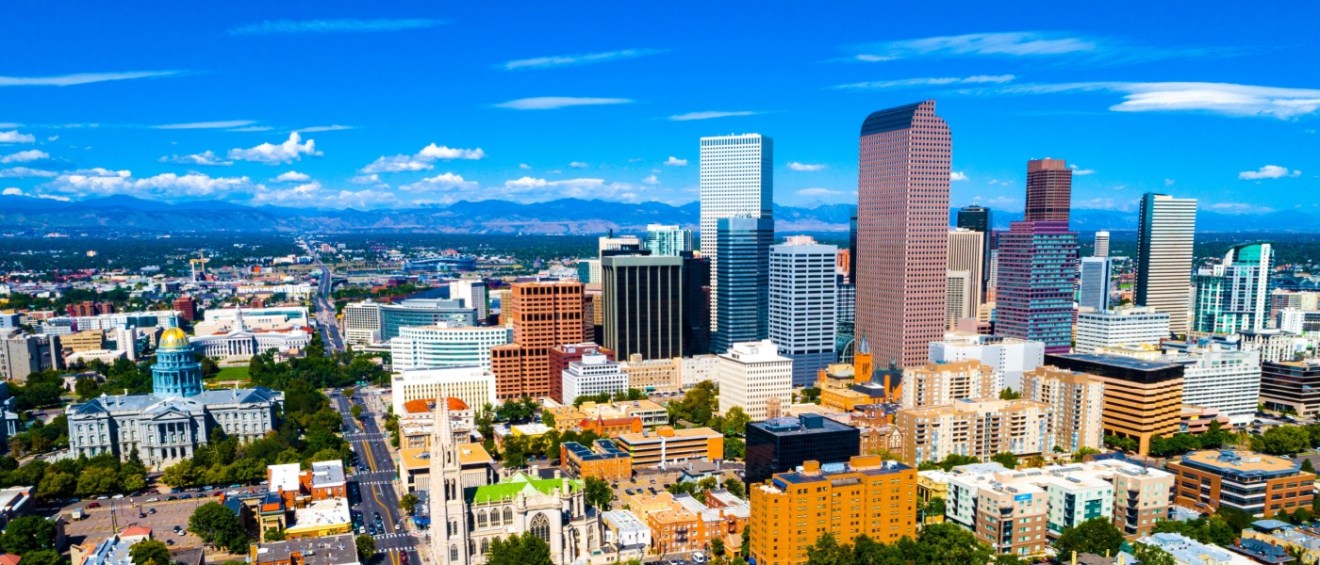 Aerial view of downtown Denver with high-rises and the State Capitol, highlighting key factors to consider before renting an apartment in the city.