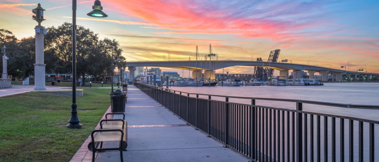 Riverwalk along St. John's River in Jacksonville, FL, at dusk, showcasing the scenic charm and affordable neighborhoods of the city.