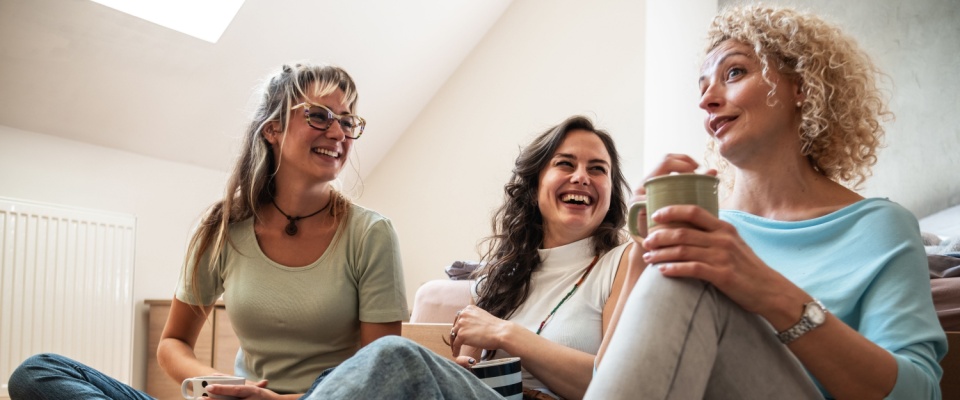 Three neighbors enjoying coffee together, sharing conversation and laughter—capturing everyday moments and the kind of connection that inspires renters to ask questions for neighbors.