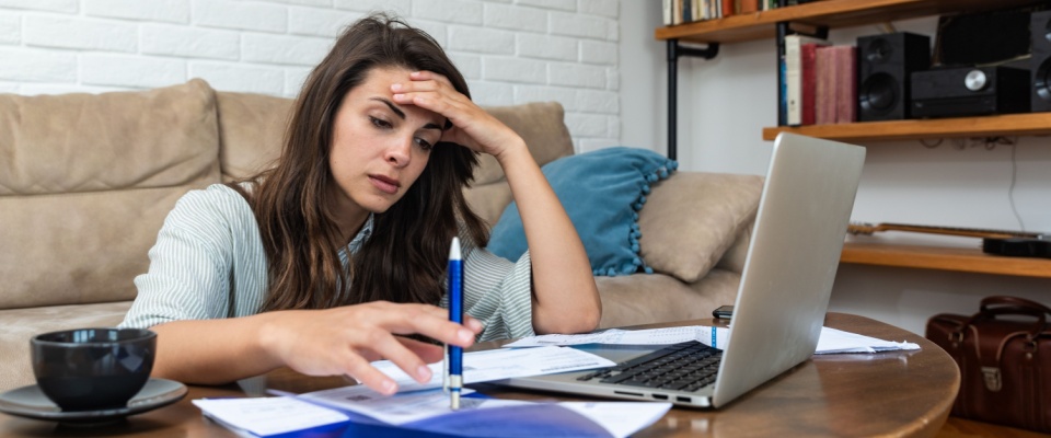A person uses a laptop to tackle their finances while proving income when self-employed.