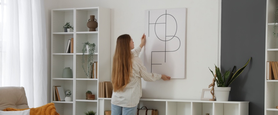 A person hangs up a poster frame after signing a lease agreement.