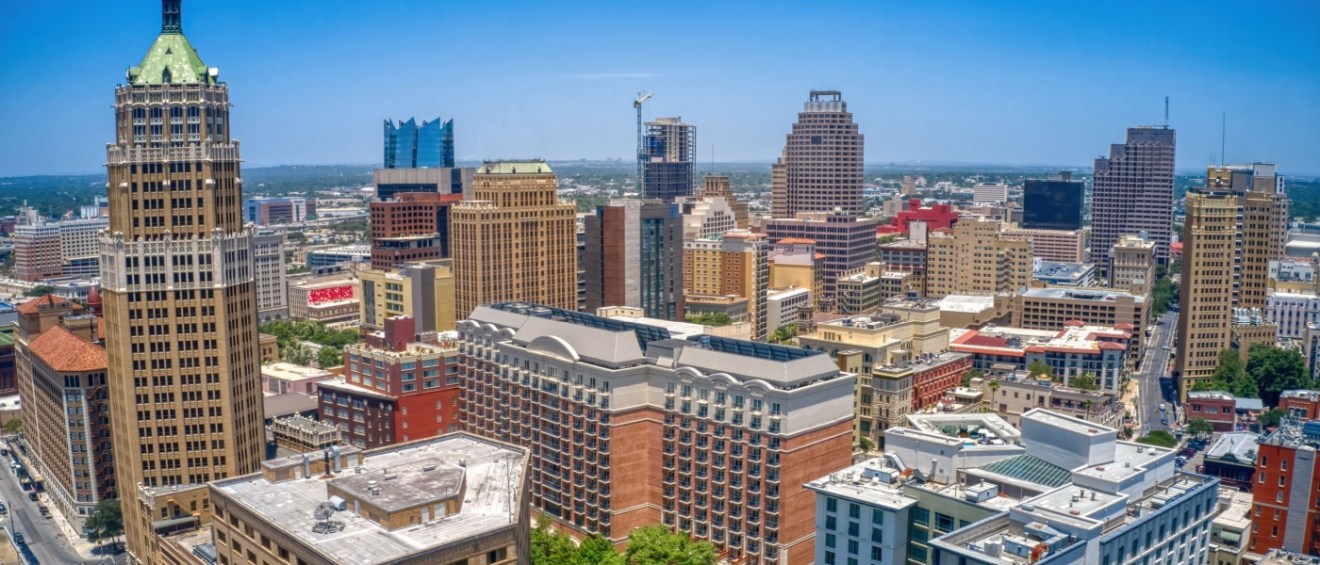 An aerial view of San Antonio during summer, showcasing the city's landscape and modern luxury apartments.