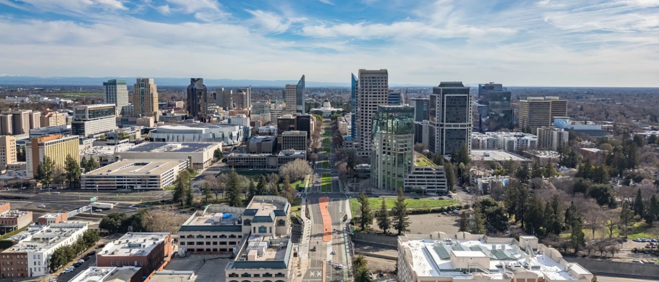 An aerial image of the Tower Bridge and State Capitol Building in Sacramento on a beautiful day after a rainstorm, highlighting the city's scenic charm and the appeal of apartments in Sacramento.
