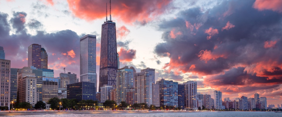 A dramatic sunset over the city highlights its dynamic skyline and urban atmosphere, emphasizing the appeal of apartments in Chicago.