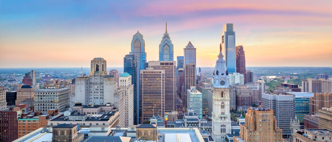Philadelphia's skyline with skyscrapers and a purple sky in the background to illustrate renting an apartment in Philadelphia.