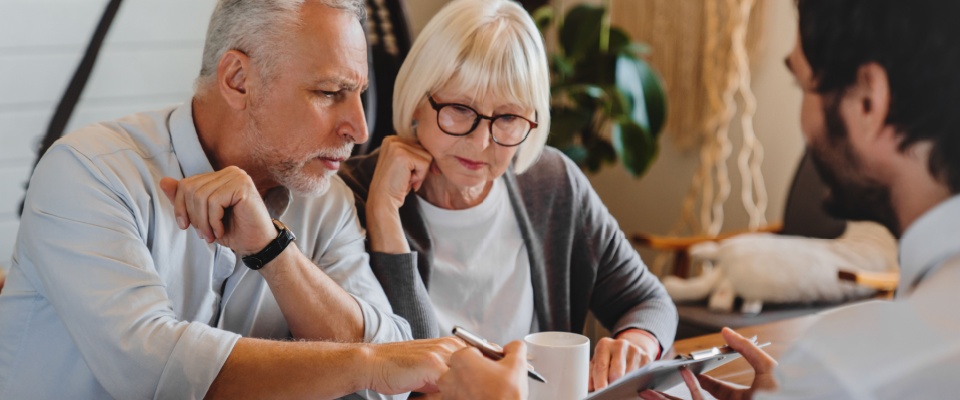Older clients consulting with a landlord, potentially exploring a great deal on a rental as part of their planning.