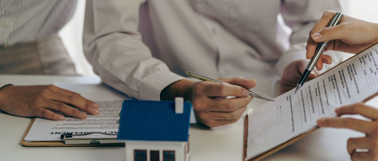 A rental company employee hands over the house key to a customer after thoroughly explaining the terms and conditions of both short-term lease and long-term lease agreements, helping them make an informed decision in the real estate rental process.