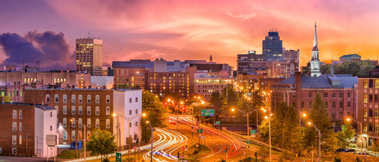 A shot of downtown Worcester, MA, pictured at dusk, a city with affordable neighborhoods where renters can find apartments for less than the local average.