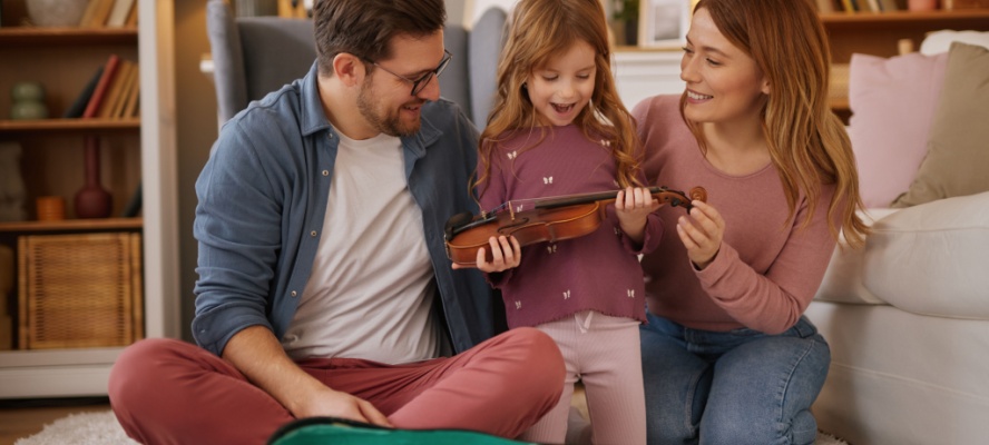 Happy family playing violin together at home