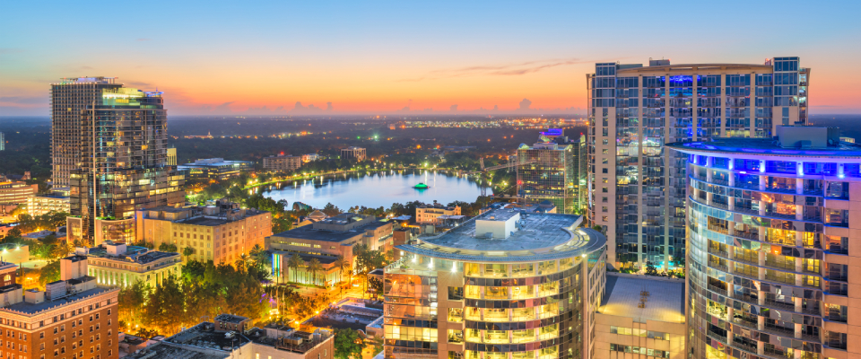 A sunset shot of the skyline in Orlando, FL, a city where the cost of living is below state and U.S. averages.