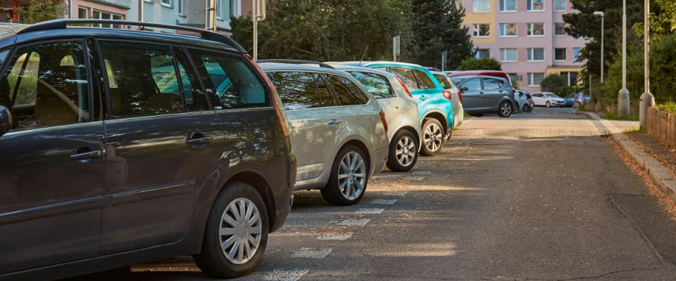Cars parked in a city suburb near residential apartment blocks, a common scene that can raise important parking questions.