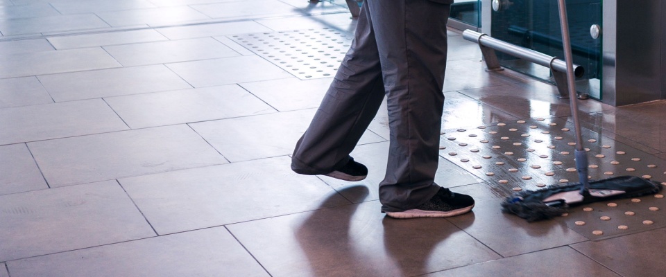 Wet mopping of tiles in a public space illustrates shared responsibility in common areas, where cleanliness and maintenance benefit all residents.