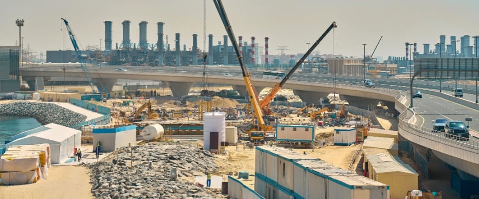 A large construction site in the Emirates showcasing cranes, scaffolding, and high-rise development—reflecting rapid urban growth and offering insights for those exploring apartments in Cincinnati by comparison.