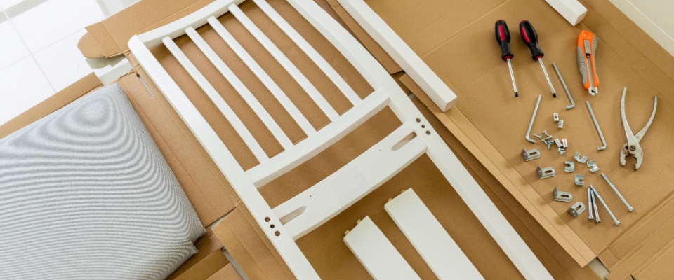 Assembling a wooden chair at home — a practical packing hack that saves space during moving and makes furniture transport more manageable.