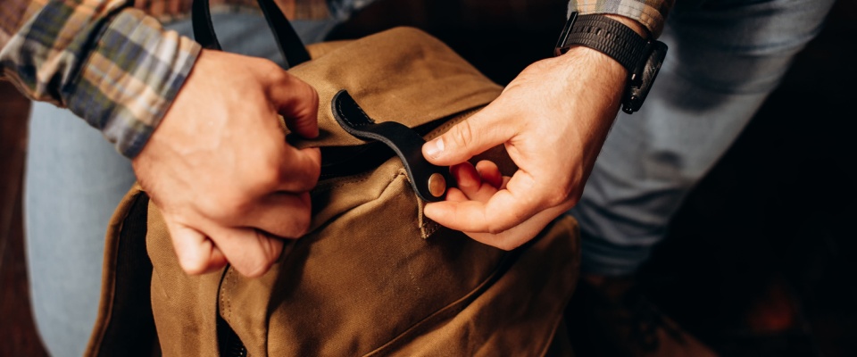 A canvas backpack being packed efficiently — showcasing smart packing hacks for travelers who value both style and functionality on the go.