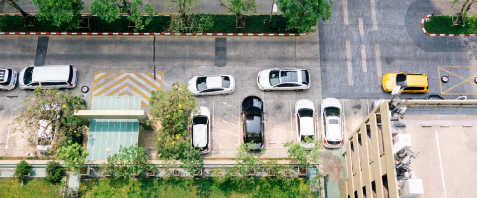 Top view of condo parking, showing a garage full of cars and greenery around the residential building — a setting that often brings up parking questions.