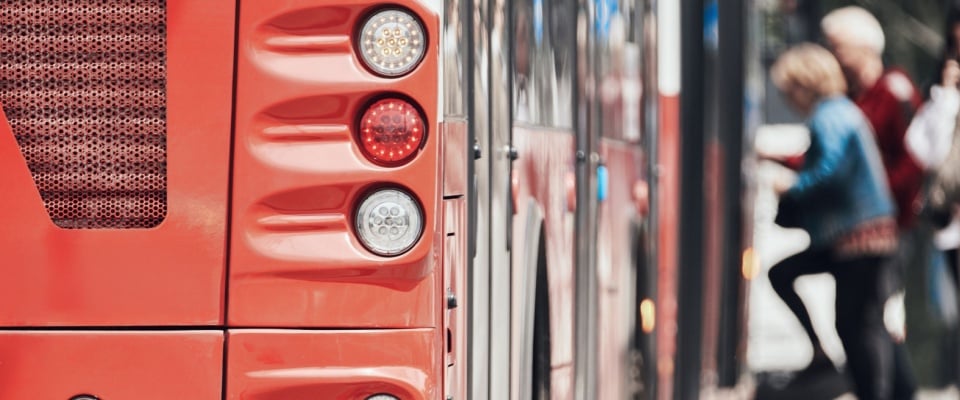 A public transportation bus driving through city streets, highlighting urban mobility and infrastructure—an important consideration for residents evaluating accessibility when searching for apartments in Cincinnati.