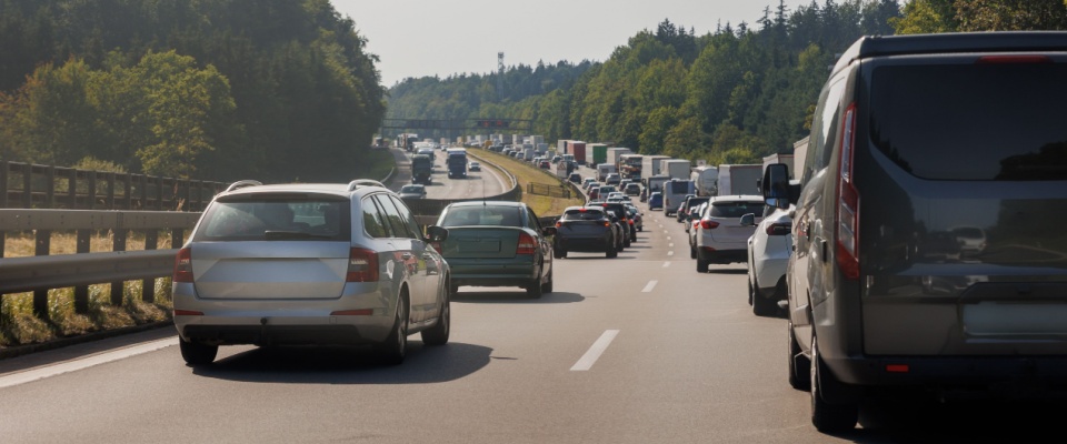 A rear view of numerous cars stuck in a traffic jam on a cold, rainy winter day in Europe underscores the importance of location and commute times when choosing apartments in Atlanta, where access to efficient transportation can greatly enhance daily living.