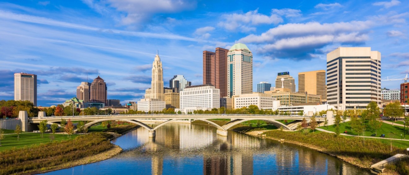 The skyline of Columbus, OH, and the Scioto River to illustrate the cost of living in Columbus.