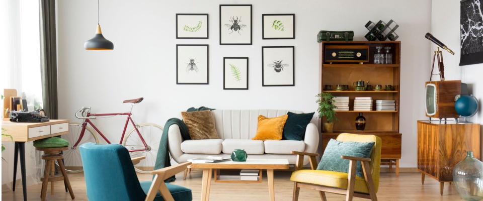 A stylish living room decorated with mid-century modern furniture and high-valuable items such as a vintage bicycle, retro electronics, artwork, and books.