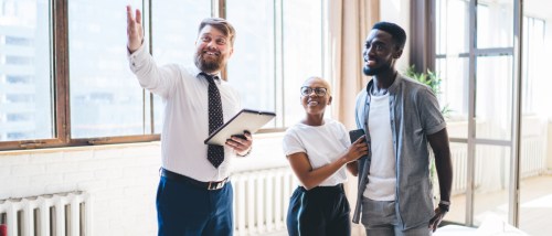 A landlord guiding a couple through their second apartment tour.