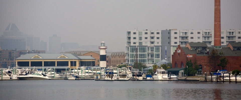A foggy morning over Baltimore’s Inner Harbor creates a peaceful waterfront scene, adding to the city’s unique atmosphere and appeal for anyone searching for apartments in Baltimore.