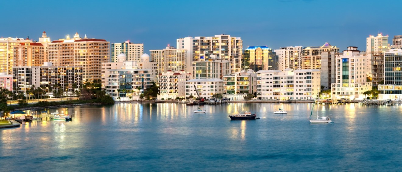 The Sarasota, FL skyline glows beautifully at night, showcasing the city’s vibrant atmosphere and making it a standout destination for those exploring affordable neighborhoods in the area.