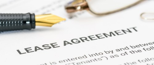 A lease agreement form with a pen and glasses highlights the importance of understanding legal documents in real estate, especially details like the lease commencement date, which marks the official start of a tenant’s rights and responsibilities.