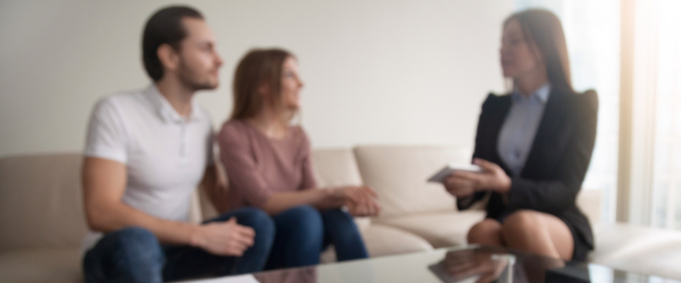 Couple discussing lease options with a real estate agent, highlighting key questions to ask before renting apartments in Detroit.