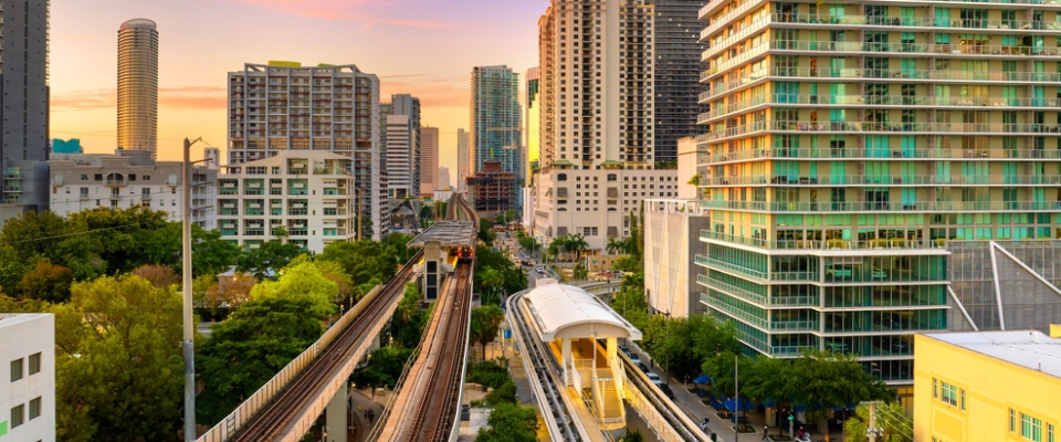 Miami Metrorail station surrounded by high-rise apartments at sunset, showcasing public transit in Miami as a convenient option for renters seeking easy commutes.