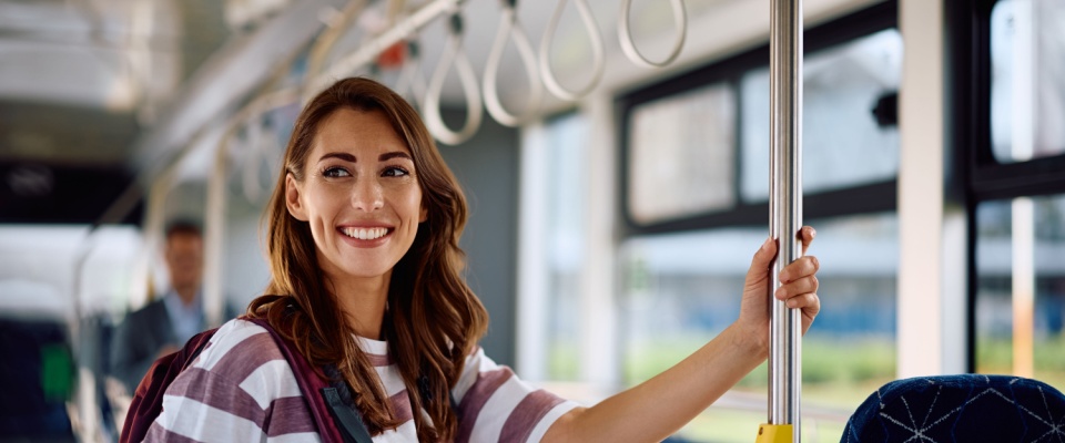 A happy woman commuting by public transport highlights the ease of city living, an important factor for those exploring apartments in Baltimore with convenient access to transit options.