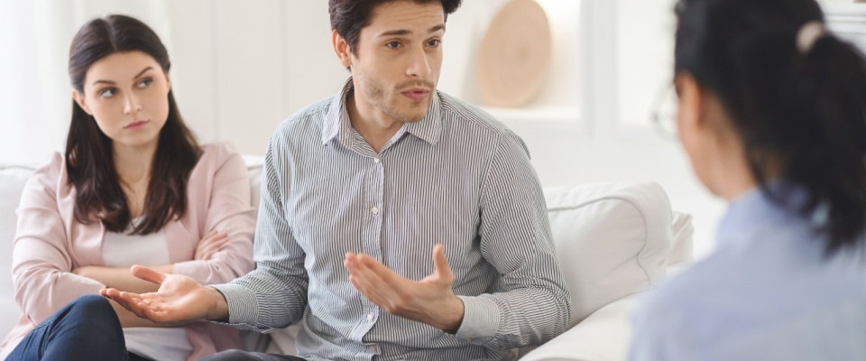 A young couple in a thoughtful counseling session, discussing communication and shared living expectations—an important step toward creating a healthy roommate agreement.