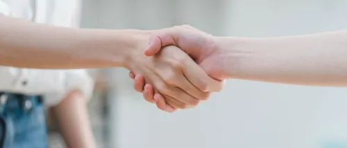 Two people shaking hands as a sign of agreement and mutual understanding, showing a peaceful way to resolve conflicts with neighbors.