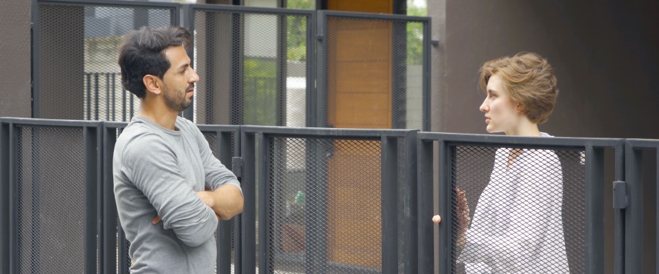Two neighbors talking calmly over a fence, working together to resolve conflicts with neighbors through open communication and finding win-win solutions.