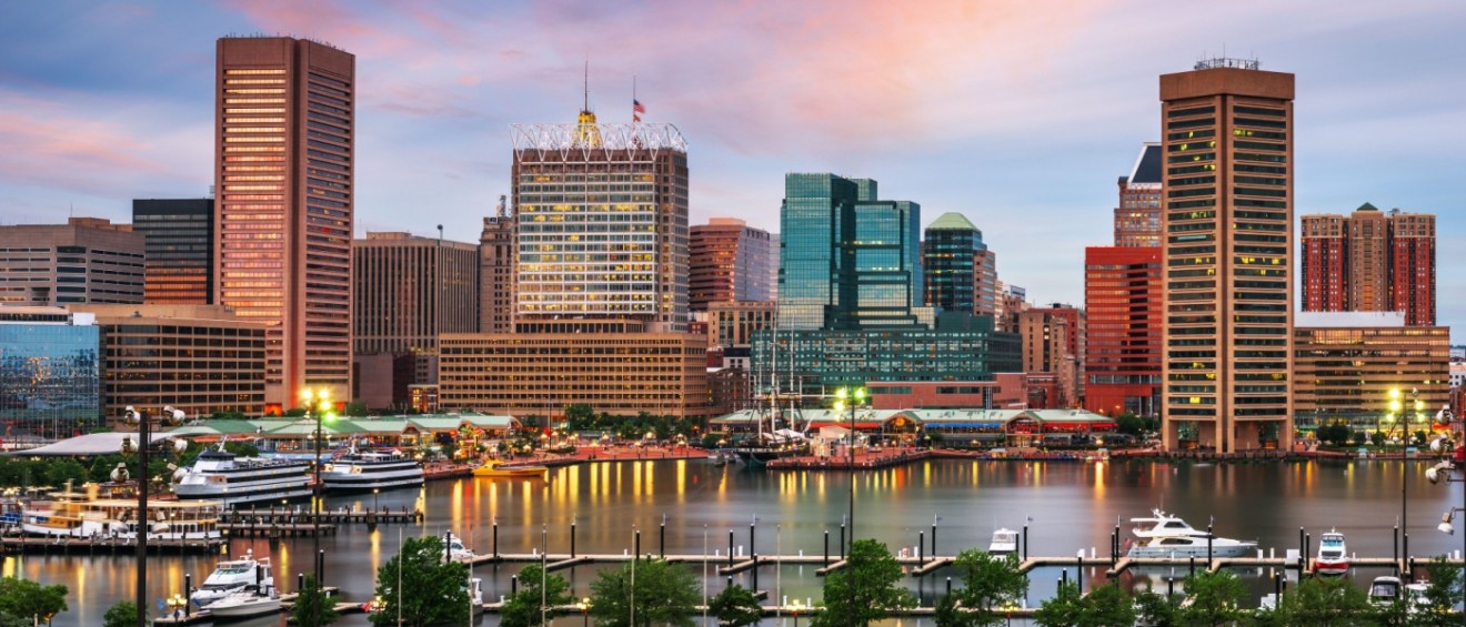Beautiful evening view of Baltimore, Maryland, with the skyline reflected over the Inner Harbor — a central hub that highlights the connection between urban life and Baltimore public transit.