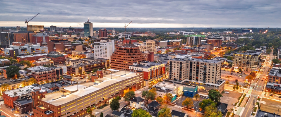 Downtown Ann Arbor, Michigan at sunset, showing apartment buildings and city streets — illustrating when to start searching for apartments in Ann Arbor’s competitive rental market.