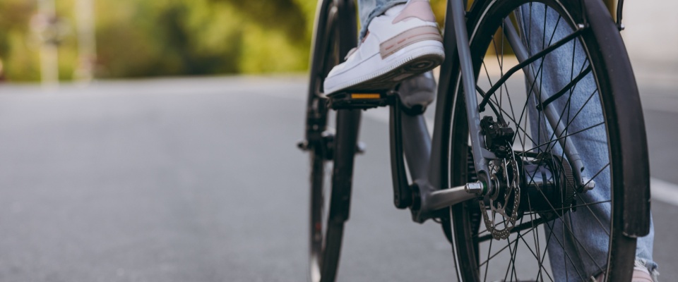 Young woman riding a bicycle and enjoying a sunny day in the city, reflecting an active and eco-friendly lifestyle supported by Milwaukee public transit.