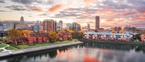 Scenic view of downtown Buffalo, NY at sunset with apartments along the waterfront, illustrating the housing and cost of living in Buffalo.