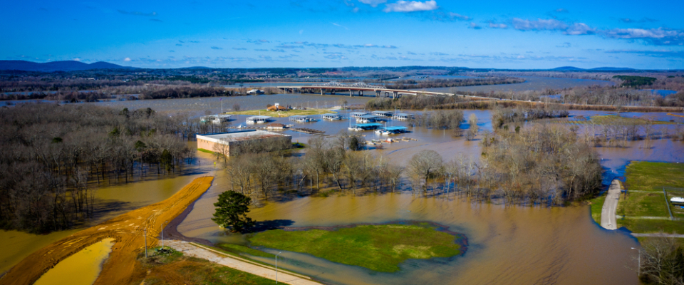 Floodwaters surrounding buildings near Huntsville, AL — reminding renters to ask about flood zones, drainage, and insurance coverage before renting apartments in Huntsville.