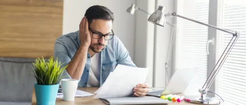 A worried man looking at a lease contract to illustrate how to face scary lease clauses as a renter.