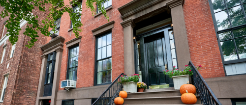 An apartment building during Halloween, with pumpkins used as decorations on the stairs.